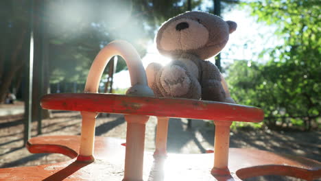 teddy bear on a swing set in a park