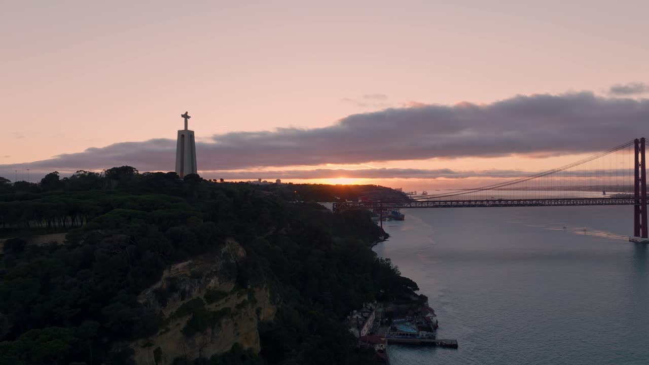 Sunset over the 25 de Abril Bridge and Cristo Rei Statue in Lisbon, Portugal