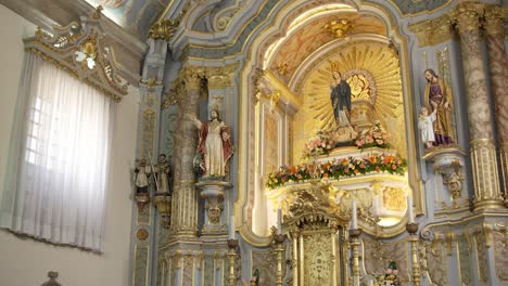 altar de la iglesia barroca con acentos de oro, estatuas religiosas y decoración floral