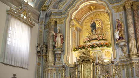 baroque church altar with gold accents, religious statues, and floral decor