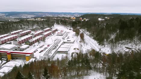 antena en movimiento hacia adelante sobre edificios y árboles cubiertos de nieve durante el invierno
