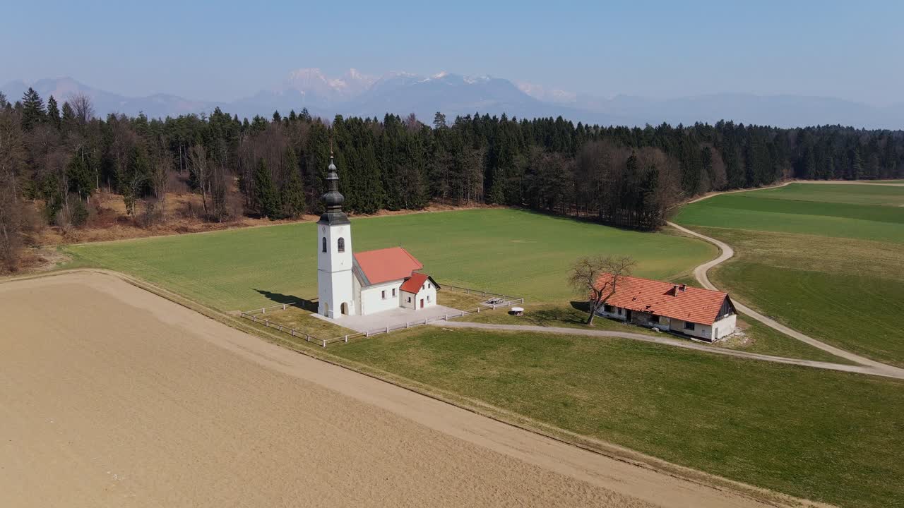 Quiet Slovenian countryside unfolds as drone leaves St Jakob Church near forest