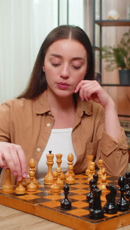 woman playing chess alone thinking deeply moving pieces slowly planning careful strategic steps