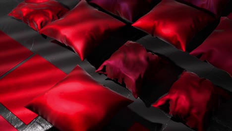 red satin pillows on dark surface