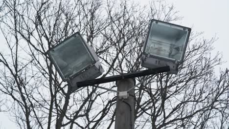 old floodlights on top of a wooden light pole