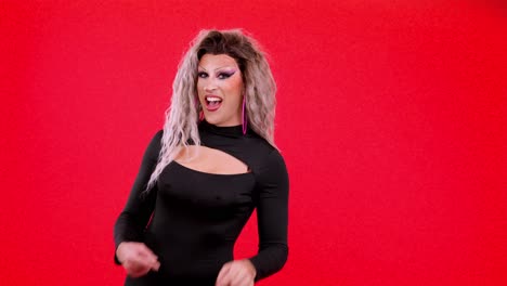 drag queen posing and pointing on a red background