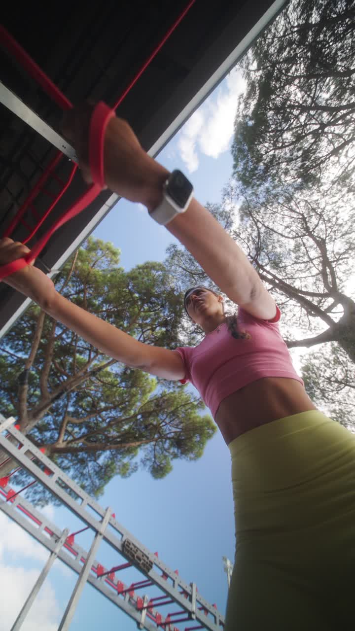Woman exercising with resistance bands at an outdoor gym