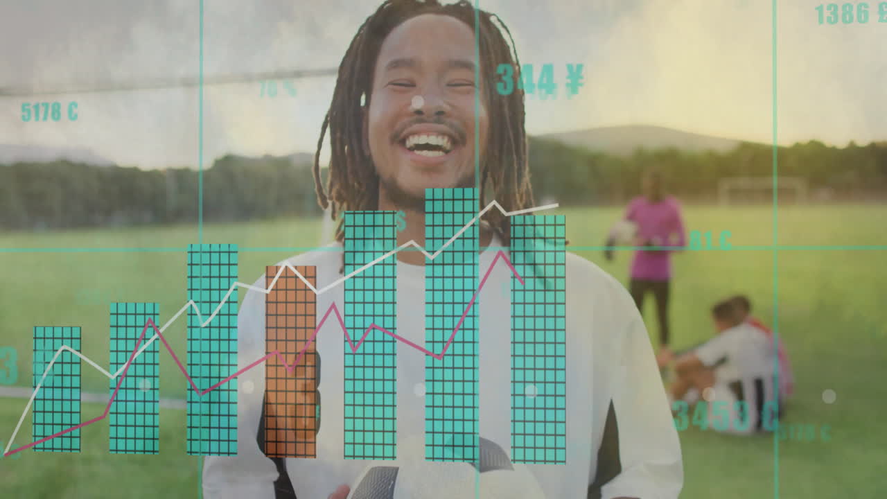 Smiling man holding soccer ball with financial data animation over sports field