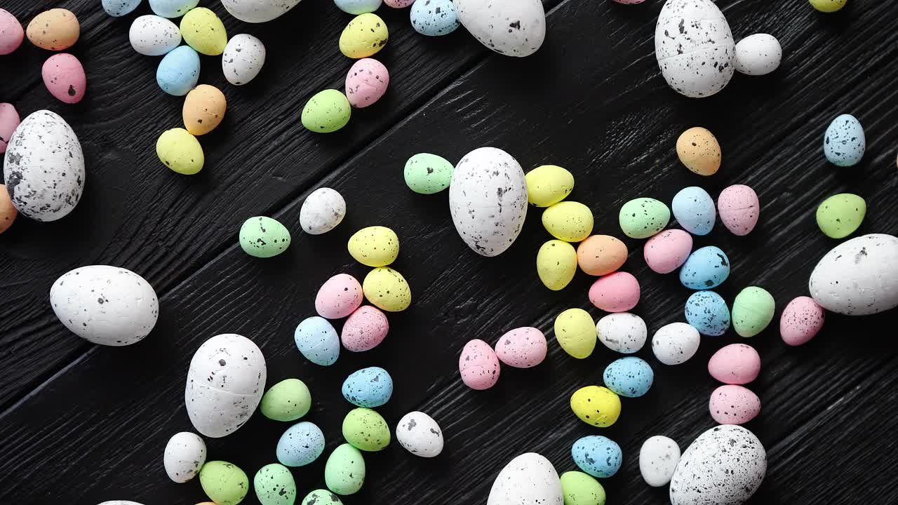 Easter holidays concept  Colorful different kinds of eggs placed on black wood