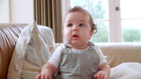 happy baby boy playing on sofa at home