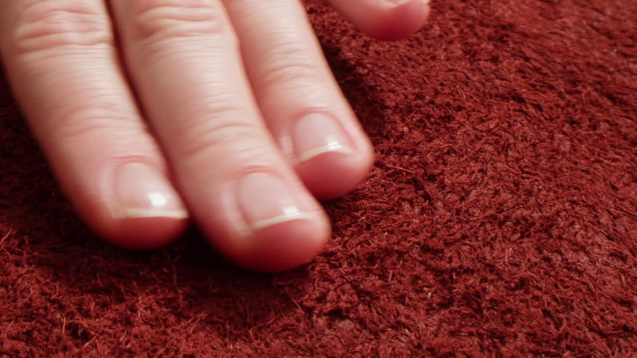Primo piano di una mano su tessuto rosso