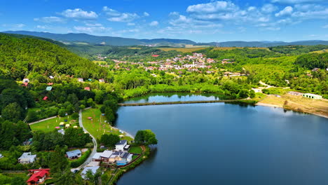 lakefront european village. a picturesque view captures a charming village nestled by a serene lake, framed by lush trees and mountains
