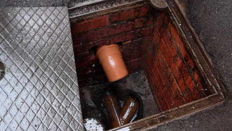 Removing-manhole-cover-and-inspecting-drain-male-worker-with-green-gloves