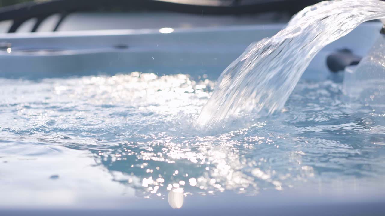 고급 주택의 야외 온수 욕조에서 물이 흐르는 모습을 클로즈업한 사진이에요