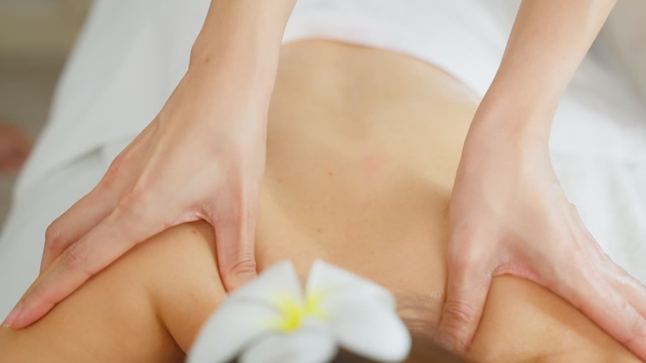 mujer recibiendo un masaje de espalda y hombro en un spa