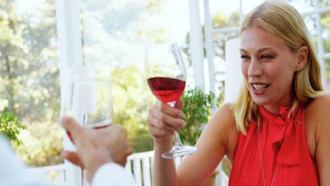 pareja brindando copas de vino tinto en un restaurante