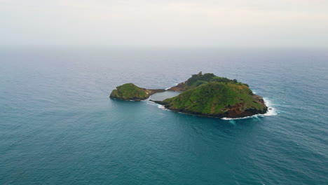 abandoned island washed ocean water aerial view. green landscape in sea middle