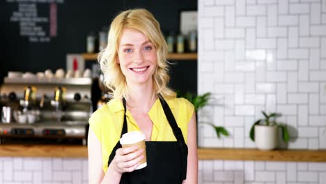 Portrait-of-waitress-holding-disposable-coffee-cup