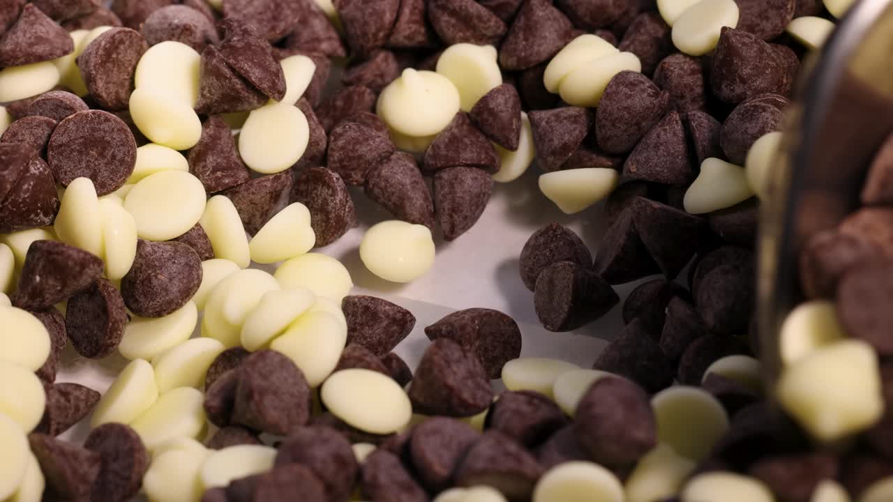 Cucchiai mescolano pezzi di cioccolato fondente e bianco
