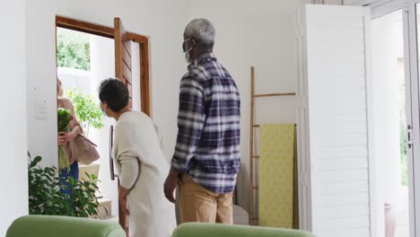 two diverse senior couples waving and greeting each other at home