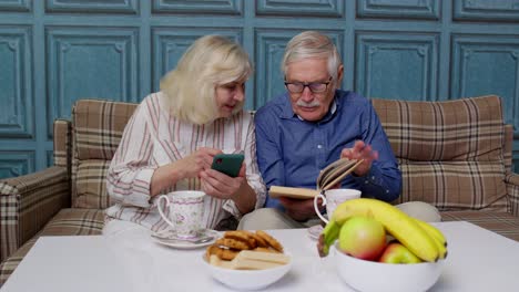 Abuelos-De-Pareja-De-Ancianos-Hablando-Y-Usando-Teléfonos-Móviles-Digitales-En-Casa.-Las-Compras-En-Línea