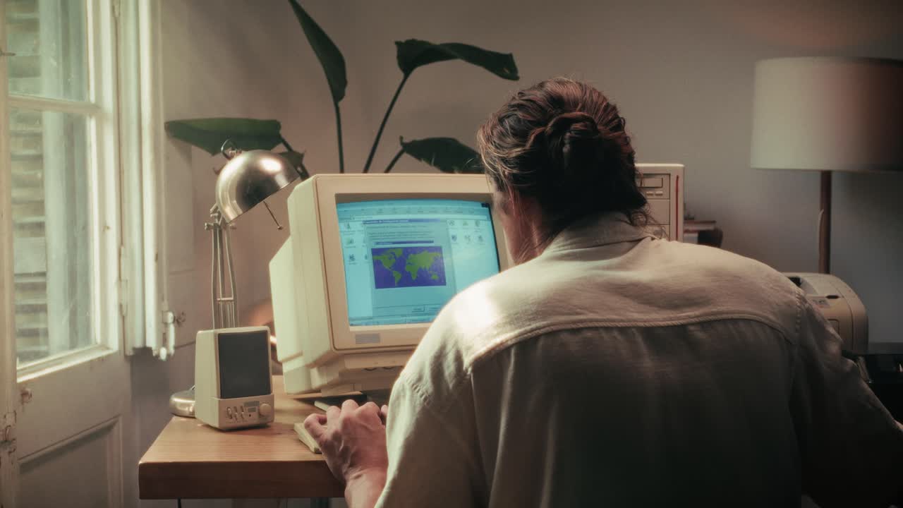 Man working and gaming on retro computer PC, IT engineer with vintage computer at home, using old fashion technology, close up of retro setup.