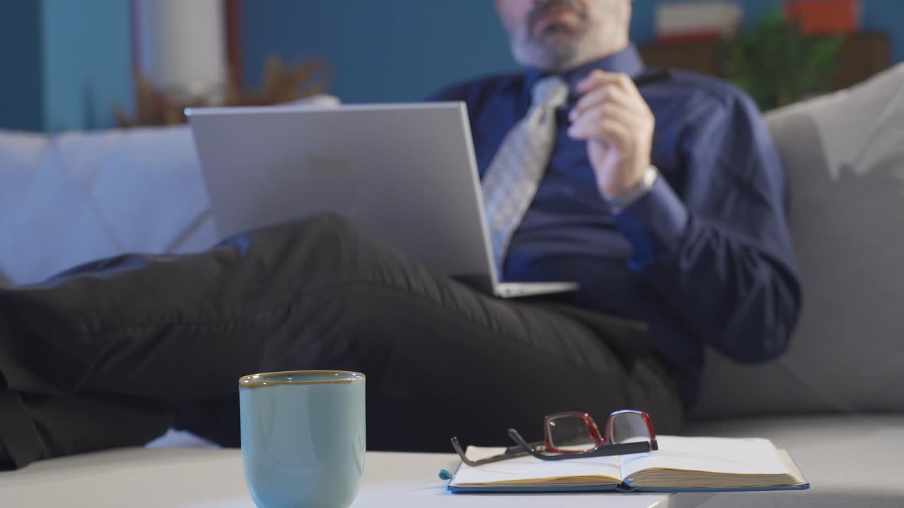Close-up of businessman looking at computer screen at home.