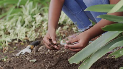 Fröhliches-Afroamerikanisches-Mädchen,-Das-Den-Boden-Im-Garten-Berührt,-Zeitlupe