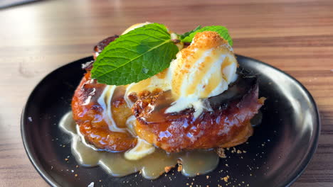 Deliciosa-Tostada-Francesa-De-Dolor-Perdu-Con-Helado-De-Vainilla-Y-Hojas-De-Menta-Fresca-En-Un-Plato,-Postre-Dulce-En-Un-Restaurante,-Toma-De-4k