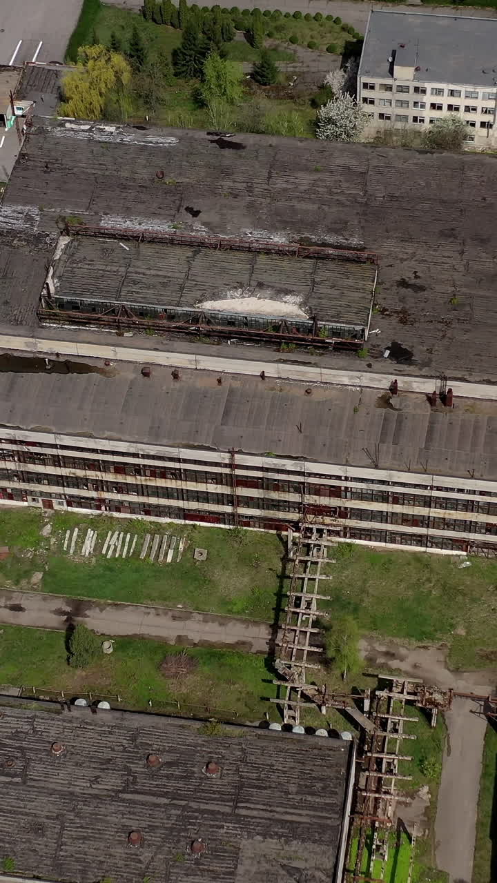 Big abandoned territory of an old factory. Ruined buildings of old industrial plant. Aerial view. Vertical video