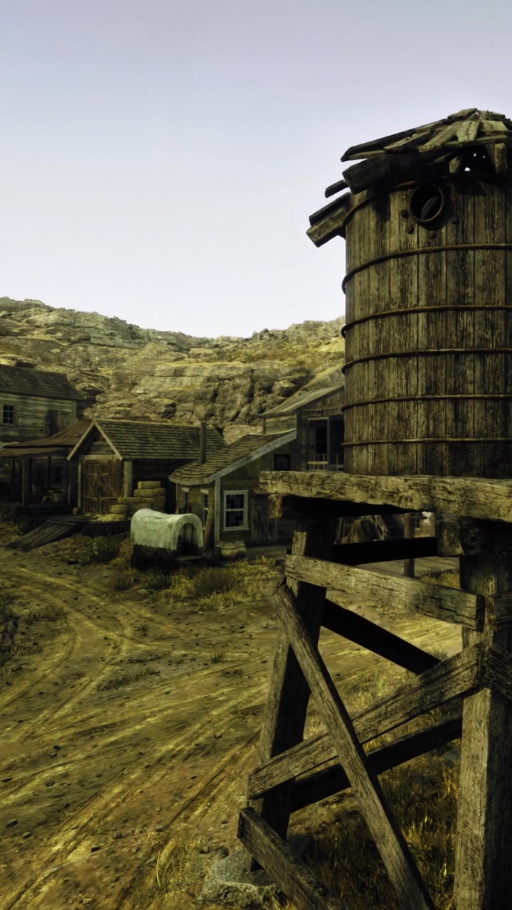 Vecchia città western con edifici in legno e una torre dell'acqua nel deserto
