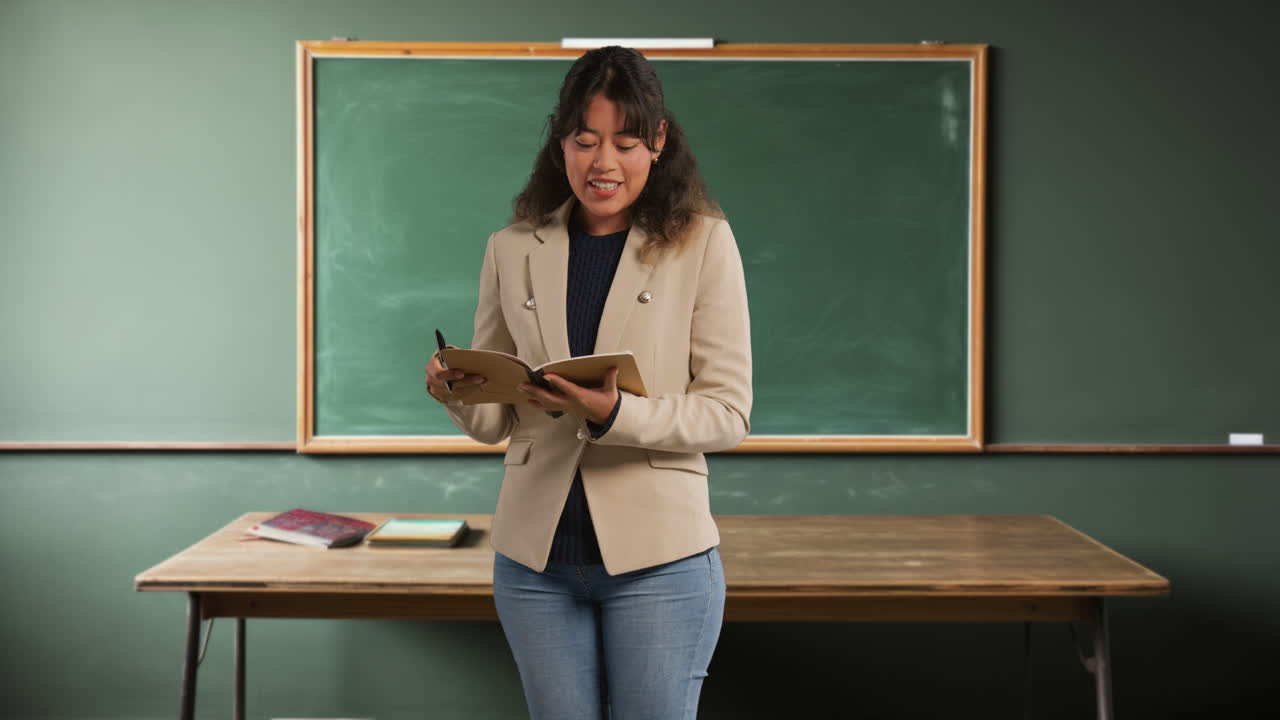 maestra en el aula de la escuela de pie frente a la junta enseñando la lección