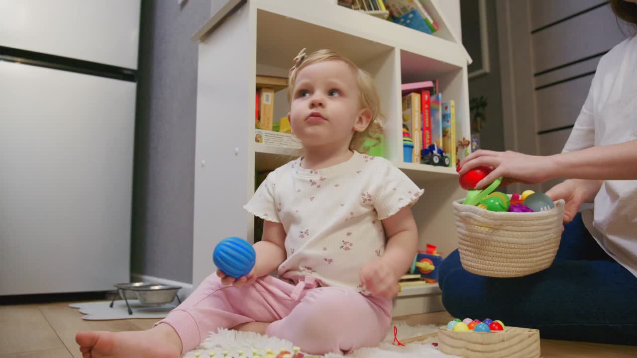 Cute Toddler Girl Playing with Toys on the Floor at Home