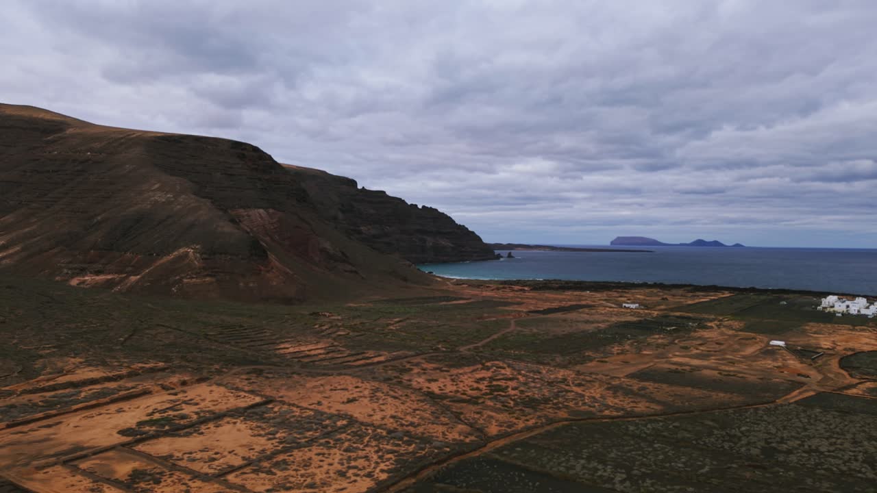 Volcanic landscape and coastline near village of Órzola in Lanzarote, Spain. Aerial drone panoramic view, copy space