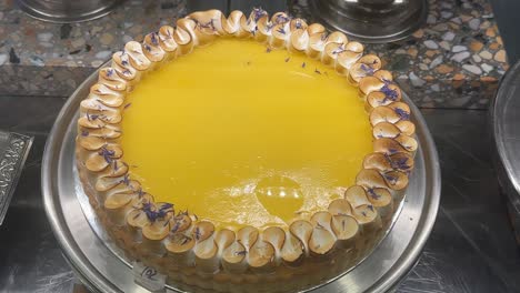yummy full lemon meringue tart cake top down shot cafe display window, australia