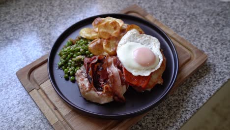 plate of costillas a la riojana with fried bacon, egg, peas and potato chips