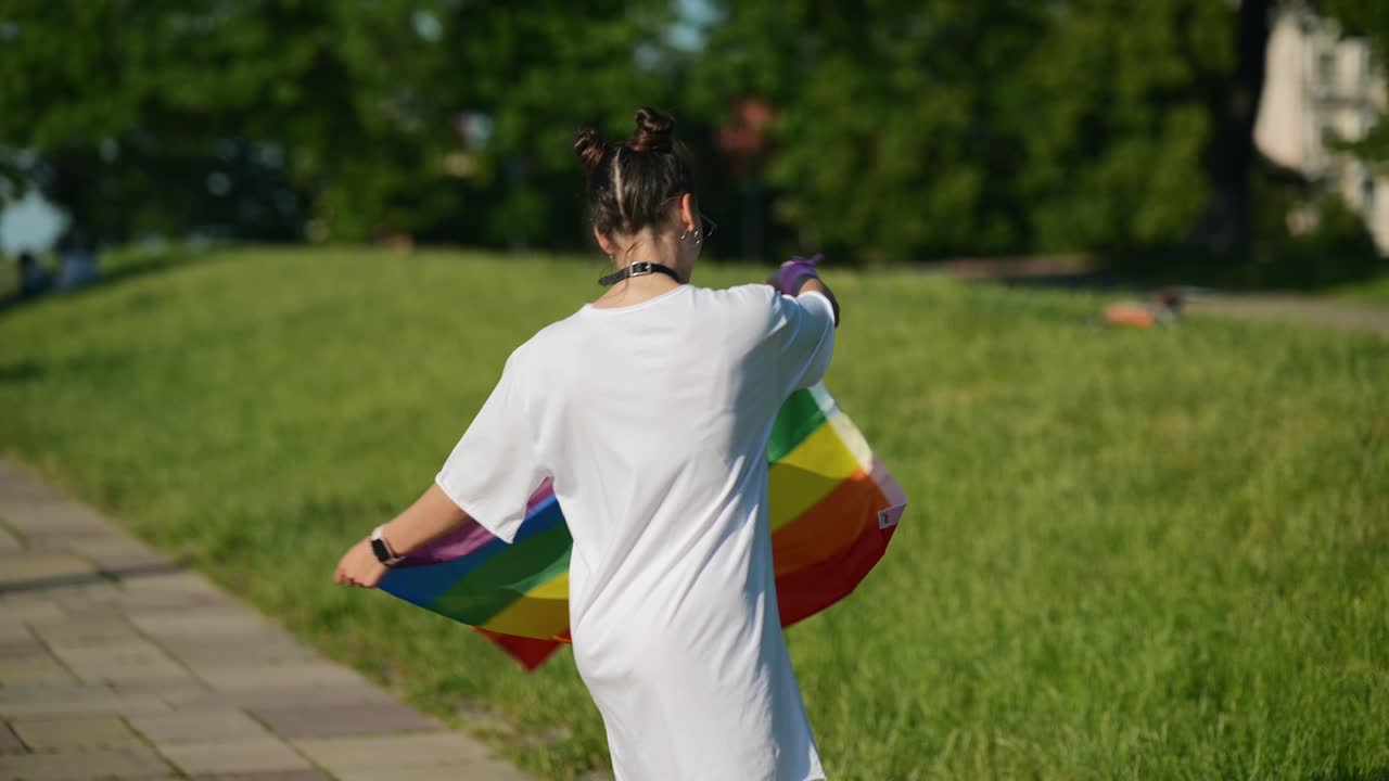 Woman holding a rainbow flag in a park