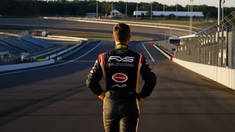 race car driver standing on an empty circuit