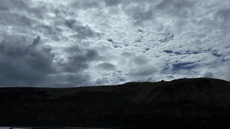 Sun-peaking-through-clouds-over-mountain