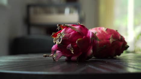 Close-up-shot-of-red-dragon-fruit-sitting-on-table-Red-Dragon-Fruit-Slices-and-Cultivating-Exotic-Plants-pitaya