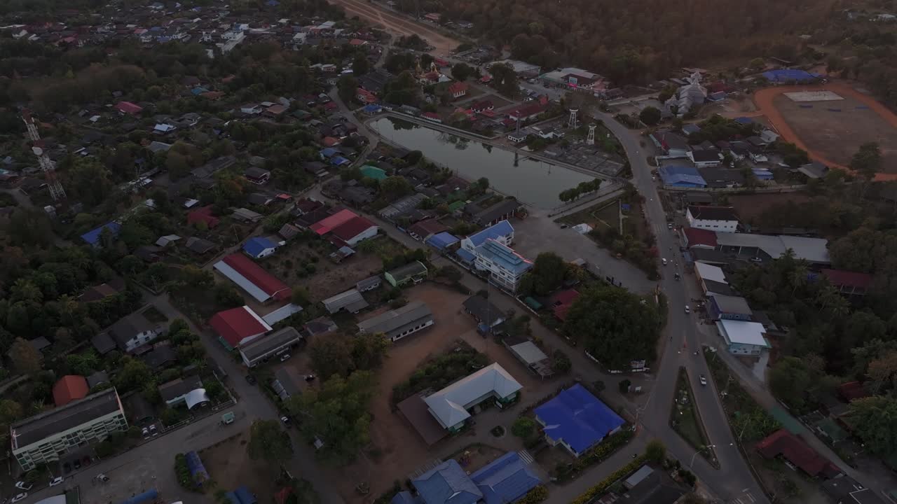 Rumah-rumah di puncak bukit bersinar di bawah langit senja yang hangat di Mae Hong Son, Thailand