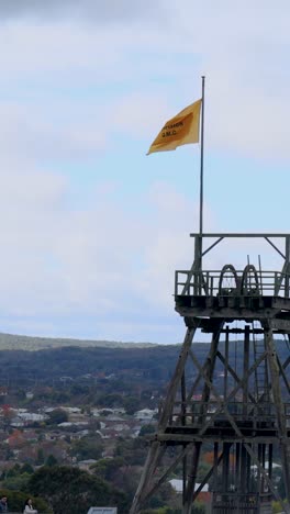 una bandera ondea en la cima de una torre contra un cielo nublado en melbourne, australia la escena captura una vista panorámica de la ciudad