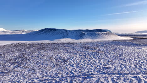 hverfjall volcano, surrounded in snow, on a clear day, aerial forward approach