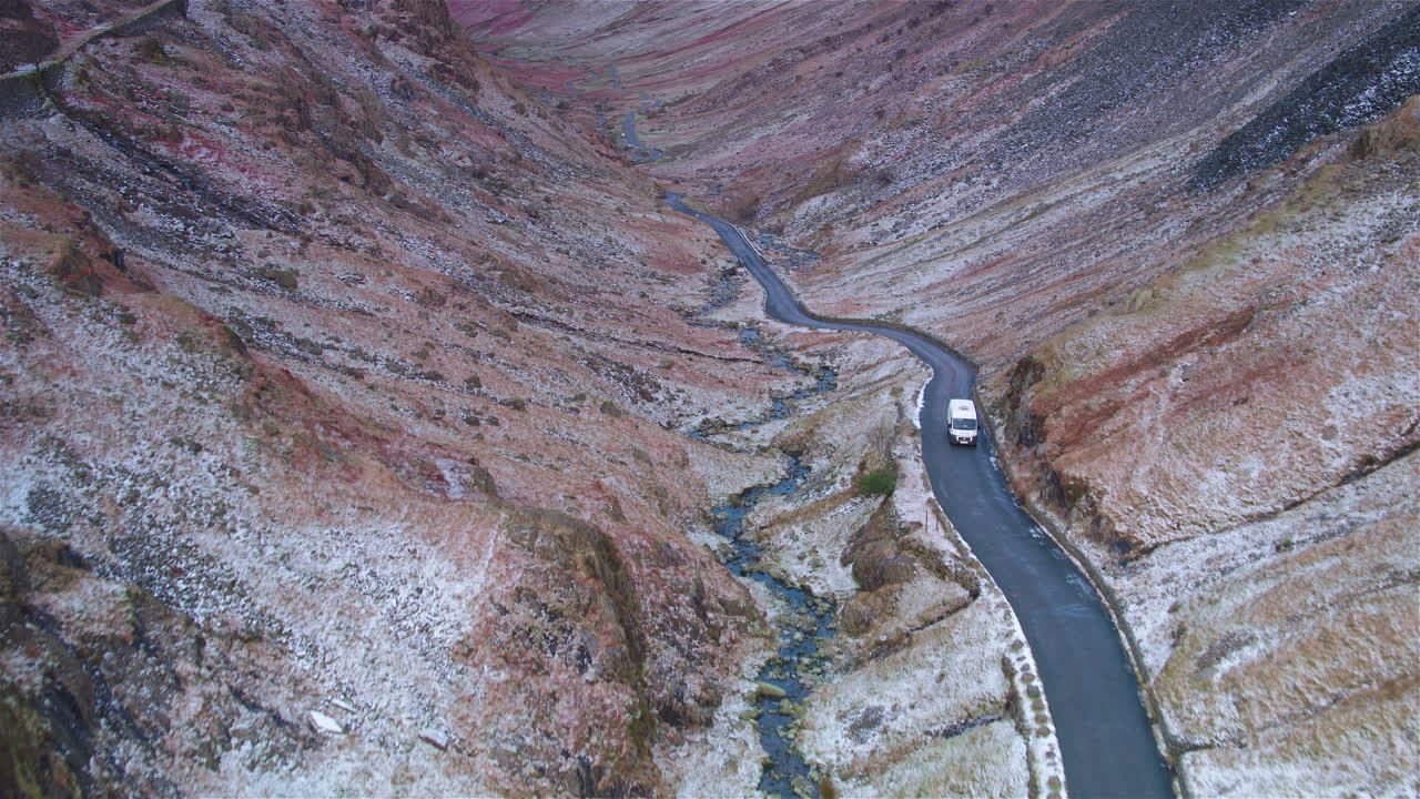 кинематографическая съемка с воздуха фургона, едущего по удаленному ландшафту