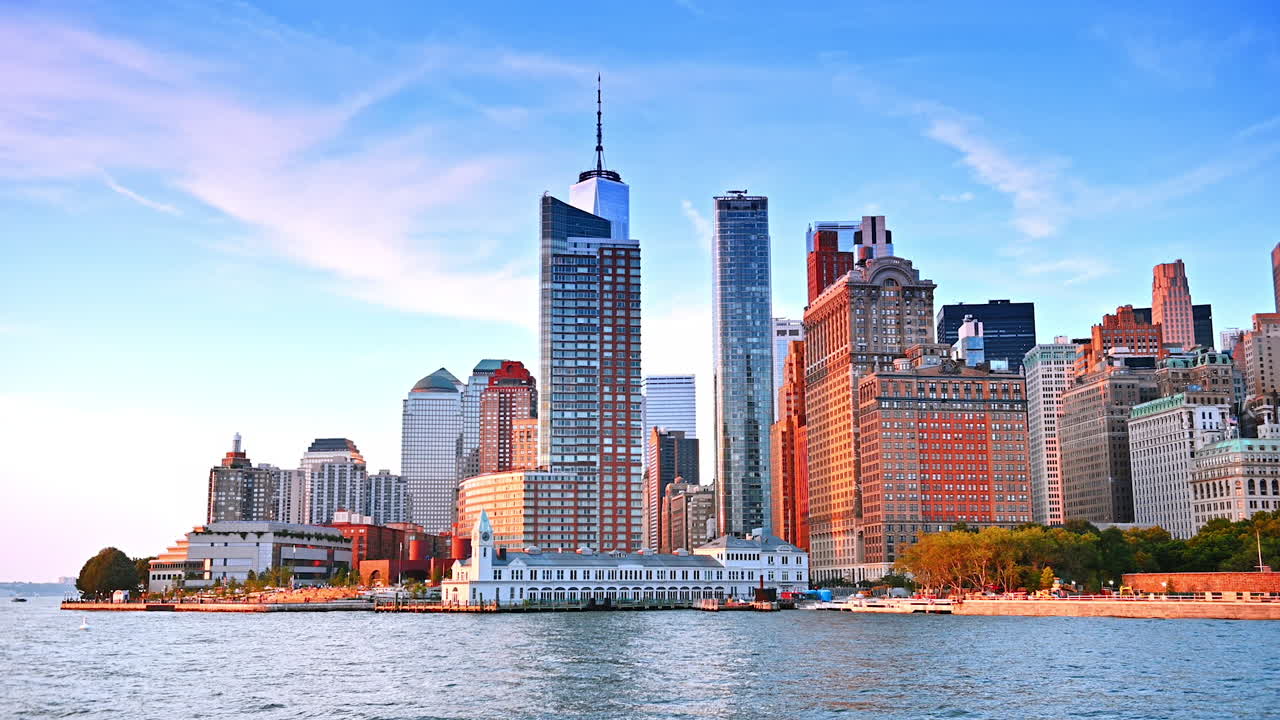 New York City skyline at sunset from the water. Beautiful sunset view of New York City skyline with skyscrapers reflecting warm light from the water