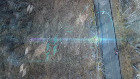 cycling teenage male riding paved path in dry park, displaying technology world map data points