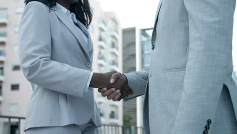 people meeting on street and shaking hands