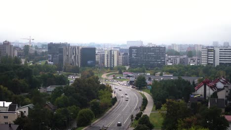 establishing shot of a city covered in fog with high rises and road leading to a city