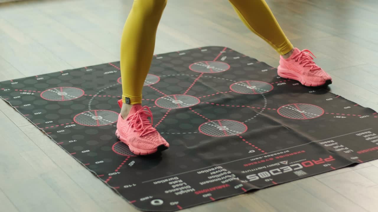 una chica hermosa está entrenando en una alfombra especial con números