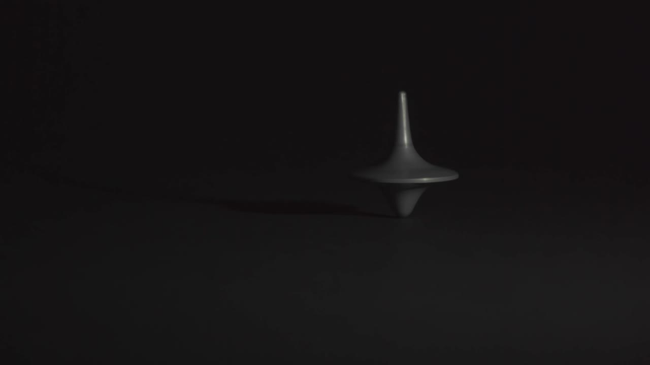 peonza en movimiento sin caer sobre fondo negro, en blanco y negro